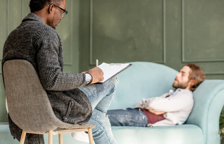 man sitting looking to the other man