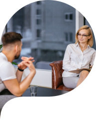 Lady psychologist with short blond hair sit with patient in her own office