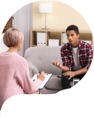 Psychotherapist working with teenage African-American boy in office