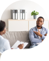 Professional psychologist helping black male patient, working with unhappy African American man, providing support and assistance at clinic