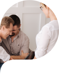 Happy delighted gay couple sitting together and hugging each other while visiting a therapist